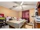 Bedroom with a ceiling fan, a window with a curtain, and a lot of stuff on the bed at 1602 N 73Rd Dr, Phoenix, AZ 85035