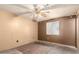 Bedroom with a ceiling fan, a window with security bars, and some damage to the walls at 1602 N 73Rd Dr, Phoenix, AZ 85035