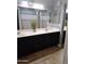 Bathroom featuring dark cabinets, dual sinks, light countertop, and wood-style floors at 16029 W Ocotillo Ln, Surprise, AZ 85374