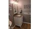 Cozy half-bathroom with updated vanity, decorative mirror, and elegant wall accents at 16029 W Ocotillo Ln, Surprise, AZ 85374