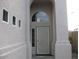 Elegant front door under arched entryway, with decorative security door and sidelight window at 16029 W Ocotillo Ln, Surprise, AZ 85374