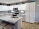 Well-lit kitchen featuring white cabinets, granite counters, stainless appliances, and island seating at 16029 W Ocotillo Ln, Surprise, AZ 85374