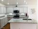 Modern kitchen with granite countertops, stainless steel appliances, and a center island at 16029 W Ocotillo Ln, Surprise, AZ 85374