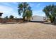 Spacious gravel backyard featuring a white, single-story house and privacy fence at 16523 N Queen Esther Dr, Surprise, AZ 85378