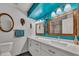 Modern bathroom with double sinks, a turquoise accent wall, and updated fixtures at 18035 N 29Th Dr, Phoenix, AZ 85053