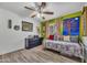 Bright bedroom features modern ceiling fan, wood floors and lots of pillows at 18035 N 29Th Dr, Phoenix, AZ 85053