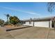 A single-story white brick home is set back from the street with desert landscaping and a long driveway at 18035 N 29Th Dr, Phoenix, AZ 85053