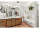 Serene bathroom with dual sinks, bathtub, a walk-in shower, and white and wood cabinetry at 19546 N 53Rd Ave, Glendale, AZ 85308