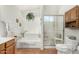 Bright bathroom with a tub, a separate shower with a frosted glass door, and white fixtures at 19546 N 53Rd Ave, Glendale, AZ 85308