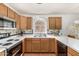 Well-lit kitchen featuring wood cabinetry, laminate countertops, and a large stainless steel sink at 19546 N 53Rd Ave, Glendale, AZ 85308