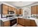 Well-equipped kitchen featuring a stainless steel microwave and range, set against tile countertops and backsplash at 19546 N 53Rd Ave, Glendale, AZ 85308