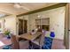 Covered patio with ceiling fans, floral wall art, and a wooden table with cushioned chairs at 19546 N 53Rd Ave, Glendale, AZ 85308