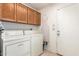 Functional laundry room with washer, dryer, storage cabinets, and an ironing board at 1956 E Calle De Caballos --, Tempe, AZ 85284
