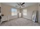 Well-lit bedroom with ceiling fan, two windows and two dressers at 20545 W Terrace Ln, Buckeye, AZ 85396