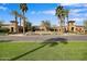 Entrance to Verrado Golf Club featuring a manicured lawn, palm trees, and a sign at 20545 W Terrace Ln, Buckeye, AZ 85396