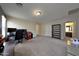 Expansive living room with neutral walls, neutral carpet, an office space, and adjacent doorway to the bathroom at 20545 W Terrace Ln, Buckeye, AZ 85396
