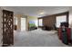 Spacious living area featuring neutral paint, neutral carpet, adjacent doorways, and natural light from the windows at 20545 W Terrace Ln, Buckeye, AZ 85396