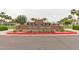 Entrance to Heritage Swim Park with a brick sign, well-manicured landscaping, and palm trees at 20545 W Terrace Ln, Buckeye, AZ 85396