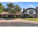 Charming two-story brick home featuring a manicured front lawn, mature tree, and brick driveway at 211 W Kaler Dr, Phoenix, AZ 85021