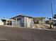 Well-kept home exterior with a large covered parking area and vibrant landscaping, showcasing curb appeal at 2121 N Center St # 131, Mesa, AZ 85201