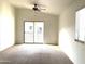 A carpeted main bedroom offers a ceiling fan, a window, and access to a balcony for an inviting, peaceful retreat at 2402 E 5Th St # 1472, Tempe, AZ 85288