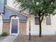 Charming townhouse features a blue front door, stone accents, and mature trees for added curb appeal at 2402 E 5Th St # 1472, Tempe, AZ 85288