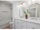 Bathroom with white cabinetry, dual sinks, and tub with tiled walls at 2743 E Virginia St, Gilbert, AZ 85296
