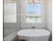 This bathroom showcases a freestanding tub, a glass enclosed shower, and a unique chandelier at 2743 E Virginia St, Gilbert, AZ 85296