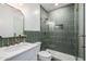 Modern bathroom featuring green tile in the shower, marble countertop, and stylish gold hardware at 2743 E Virginia St, Gilbert, AZ 85296