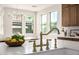 Close-up of a gold faucet and lemon display on a marble island with open-concept dining area at 2743 E Virginia St, Gilbert, AZ 85296