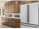Kitchen with ample custom cabinetry, stainless steel refrigerator, and marble countertops at 2743 E Virginia St, Gilbert, AZ 85296