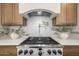Close-up of the kitchen range, backsplash, and cabinets with pot filler and decor at 2743 E Virginia St, Gilbert, AZ 85296