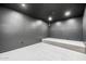 A cozy theater room with carpeted floor, gray walls, and elevated seating platform at 2743 E Virginia St, Gilbert, AZ 85296