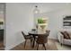 Bright dining area with round table, leather chairs, decorative light fixture, and a large window at 2753 E Aster Dr, Phoenix, AZ 85032