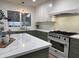 Bright kitchen featuring sage and white cabinets, stainless steel oven, and marble countertops with modern fixtures at 2753 E Aster Dr, Phoenix, AZ 85032