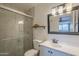 Bathroom features a white vanity, framed mirror, and shower with glass door at 2818 E Clarendon Ave, Phoenix, AZ 85016
