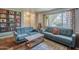 Inviting living room featuring blue sofas, unique coffee table, and decoratively adorned walls with vintage records at 2818 E Clarendon Ave, Phoenix, AZ 85016