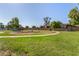 Community playground area with green grass, trees and walking path at 3646 N 67Th Ave # 29, Phoenix, AZ 85033