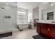 Bright bathroom with a glass-enclosed shower, soaking tub, and a stylish vanity with good natural light at 36922 N Camarillo Dr, San Tan Valley, AZ 85140
