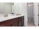 Bathroom featuring a cherry wood vanity with double sinks and a mirror with access to the shower room at 36922 N Camarillo Dr, San Tan Valley, AZ 85140
