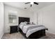 Bedroom features a dark wood bedroom set, a plush carpet, and bright window overlooking the neighborhood at 36922 N Camarillo Dr, San Tan Valley, AZ 85140