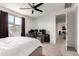 Bright bedroom featuring a ceiling fan, large window, and an office setup with multiple monitors at 36922 N Camarillo Dr, San Tan Valley, AZ 85140