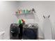 This laundry room is equipped with modern appliances and a shelf for storage, designed for convenience at 36922 N Camarillo Dr, San Tan Valley, AZ 85140