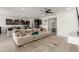 Bright open-concept living room featuring a large sectional couch, modern ceiling fan, and seamless flow to kitchen at 36922 N Camarillo Dr, San Tan Valley, AZ 85140