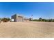 A detached three-car garage with desert landscaping and a trailer on a sunny day at 38415 N 25Th Ave, Phoenix, AZ 85086