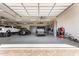 Large garage with multiple vehicles, arcade game, and storage, showcasing a spacious area at 38415 N 25Th Ave, Phoenix, AZ 85086