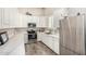Bright kitchen with stainless steel appliances, white cabinets, and wood-look tile flooring at 38415 N 25Th Ave, Phoenix, AZ 85086
