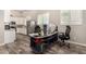 Office space open to a kitchen with stainless appliances, white cabinetry, and wood-look tile flooring at 38415 N 25Th Ave, Phoenix, AZ 85086