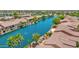 Aerial view capturing a community with waterfront properties, mature trees, and serene water at 42485 W Abbey Rd, Maricopa, AZ 85138