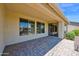Covered back patio area with stylish brick pavers, offering shade and beautiful views of the yard at 42485 W Abbey Rd, Maricopa, AZ 85138